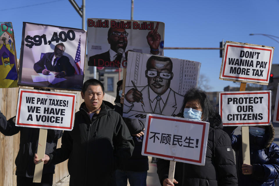 Protesters hold signs outside of the construction site of a government-run tent encampment for migrants Wednesday, Nov. 29, 2023, in the Brighton Park neighborhood of Chicago. (AP Photo/Erin Hooley)