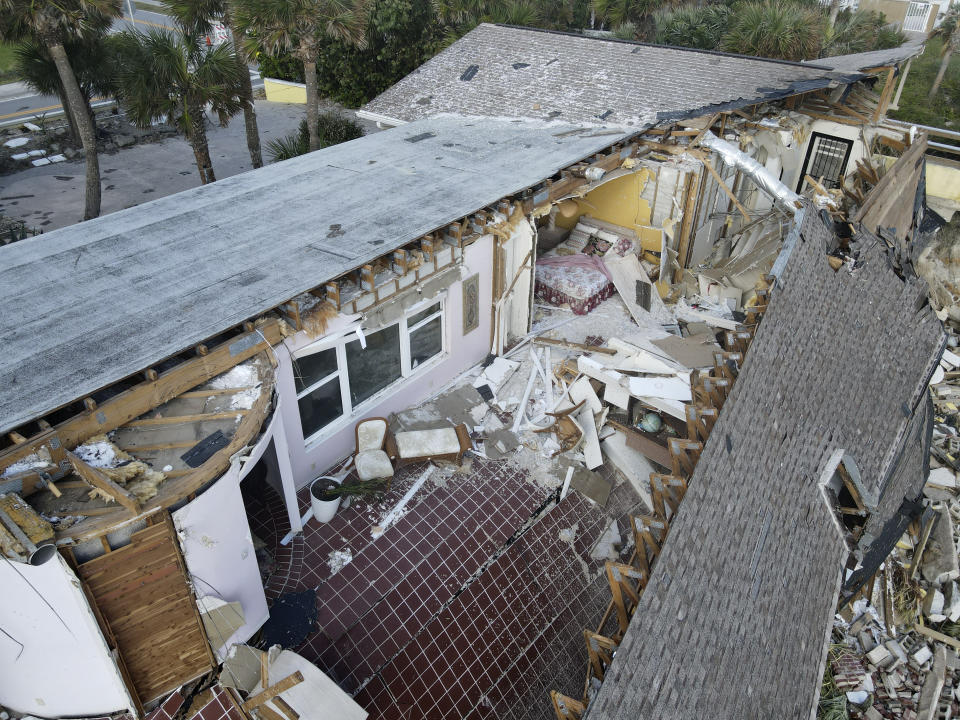 Una cama y algunas sillas dentro de una residencia que se colapsó parcialmente después de que los soportes fueron arrastrados tras el paso del huracán Nicole, el sábado 12 de noviembre de 2022, en Wilbur-By-The-Sea, Florida. (AP Foto/Rebecca Blackwell)