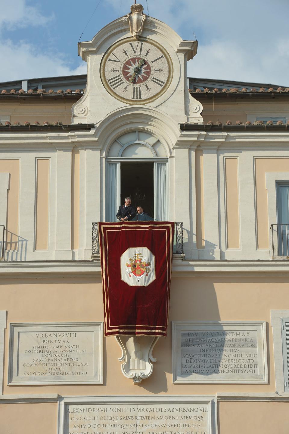 Tout est prêt à Castel Gandolfo - Un drap de velours rouge et or pendait à la fenêtre depuis laquelle Benoît XVI devait faire sa dernière apparition publique en tant que pape. Sur les balcons, terrasses et fenêtres alentours, la foule a brandi le drapeau jaune et blanc du Vatican. VINCENZO PINTO/AFP