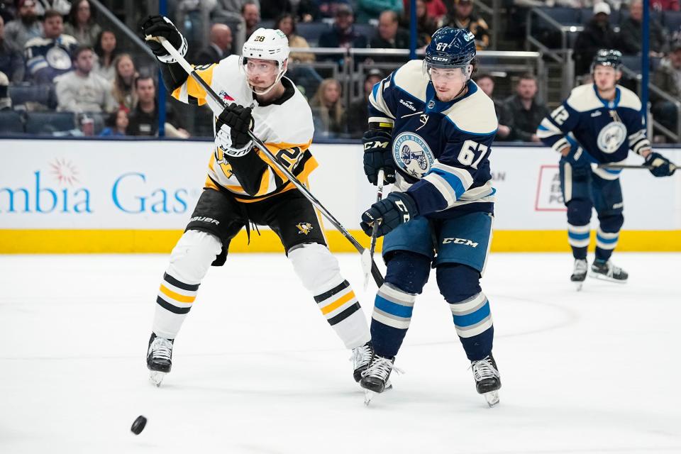 Mar 30, 2024; Columbus, Ohio, USA; Columbus Blue Jackets left wing James Malatesta (67) tries to redirect a puck past Pittsburgh Penguins defenseman Marcus Pettersson (28) during the first period of the NHL hockey game at Nationwide Arena.