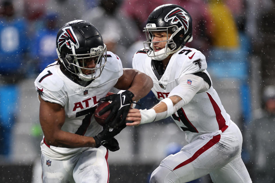 Desmond Ridder #9 of the Atlanta Falcons hands the ball to teammate Bijan Robinson #7 