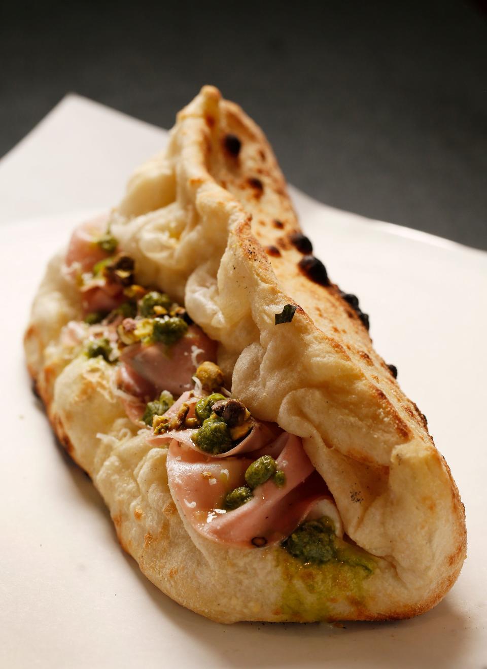 The Pistachio Whisperer Panuozzo at Rodrigo's Craft Pizza is made with pistachio pesto, burrata, mortadella, pistachio bits, extra virgin olive oil and Parmigiano cheese.