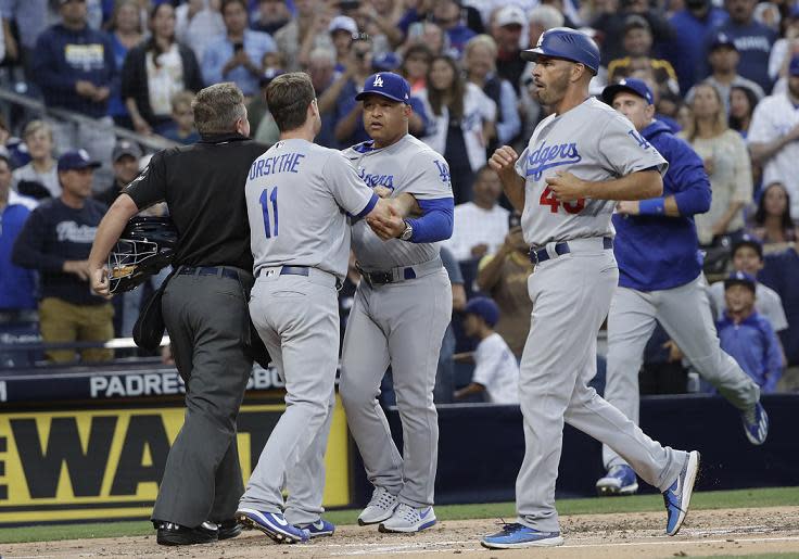 Los Angeles Dodgers manager Dave Roberts (center) is held back after getting into a heated confrontation with Padres manager Andy Green. (AP)