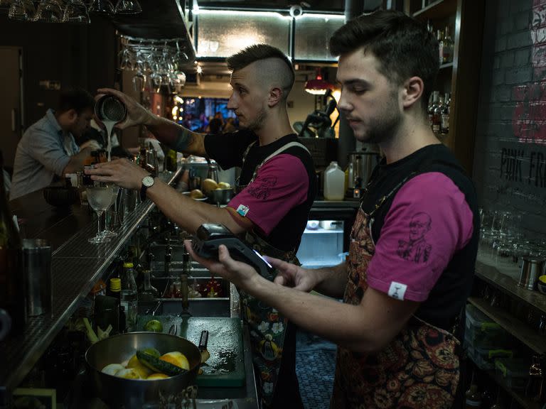 Los camareros toman los últimos pedidos antes de que comience el toque de queda nocturno en el Pink Freud, un bar de Kiev, el 15 de julio de 2022
