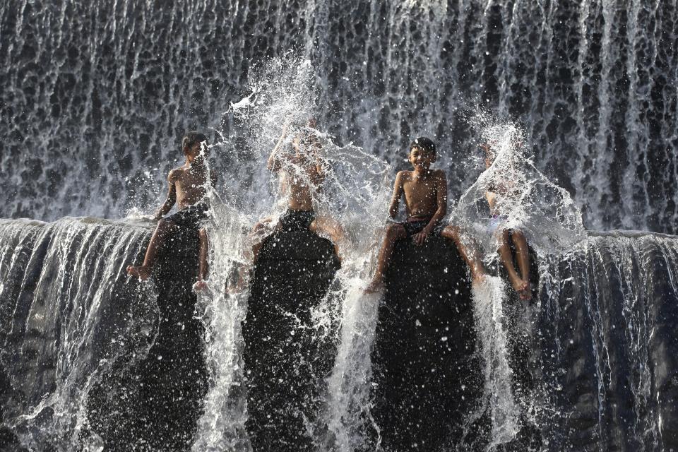 Residents sit in a dam of Unda River, ahead of World Water Day, in Klungkung, Bali, Indonesia, Tuesday, March 19, 2024. (AP Photo/Firdia Lisnawati)