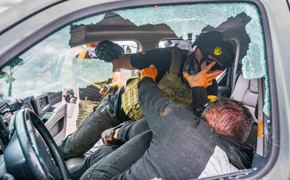 A member of the far-right group Proud Boys and a left-wing counter protester fight in a truck - Getty Images North America 