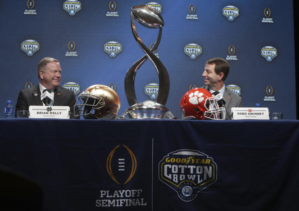 Notre Dame head coach Brian Kelly, left, and Clemson head coach Dabo Swinney share a moment during the NCAA Cotton Bowl football coaches' news conference in Dallas, Friday, Dec. 28, 2018. Notre Dame is scheduled to play Clemson in the NCAA Cotton Bowl semi-final playoff Saturday. (AP Photo/LM Otero)