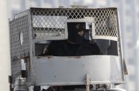 A riot policeman sits inside a police vehicle on October bridge during clashes with anti-government protesters and members of the Muslim Brotherhood, near Tahrir Square in downtown Cairo, on the third anniversary of Egypt's uprising, January 25, 2014. Twenty-nine people were killed during anti-government marches on Saturday while thousands rallied in support of the army-led authorities, underlining Egypt's volatile political fissures three years after the fall of autocrat President Hosni Mubarak. Security forces lobbed teargas and some fired automatic weapons in the air to try to prevent demonstrators opposed to the government reaching Tahrir Square, the symbolic heart of the 2011 uprising that toppled the former air force commander. (REUTERS/Mohamed Abd El Ghany)