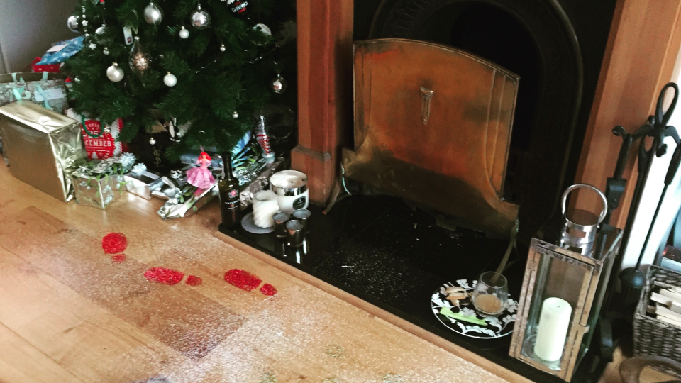 Glittery footprints beside a fireplace