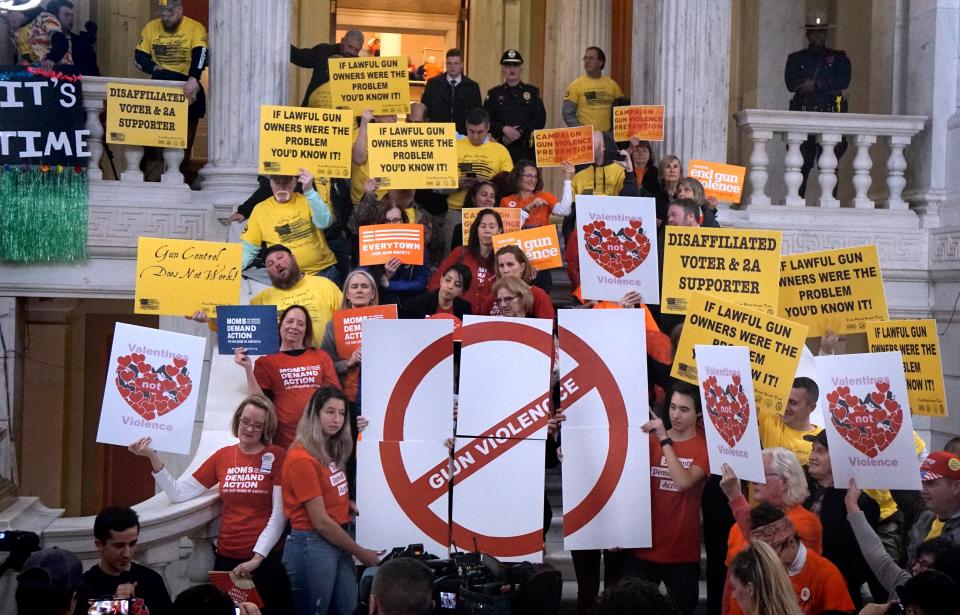 Supporters of gun-control legislation rally at the State House rotunda in 2020, surrounded by Second Amendment rights supporters.