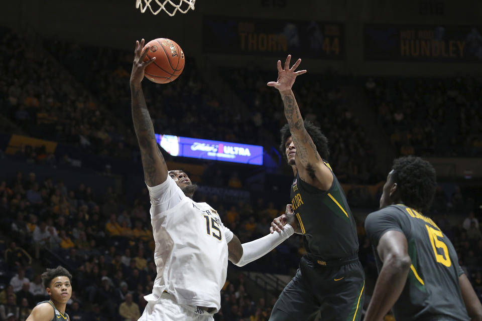 West Virginia forward Jimmy Bell Jr. (15) is defended by Baylor forward Jalen Bridges (11) during the second half of an NCAA college basketball game in Morgantown, W.Va., Wednesday, Jan. 11, 2023. (AP Photo/Kathleen Batten)