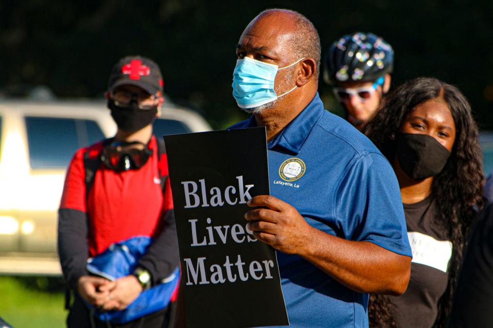 Bishop John Milton of the Lafayette branch of the NAACP holds a sign during a Friday evening protest against police brutality in front of the Louisiana Governor's Mansion in Baton Rouge.