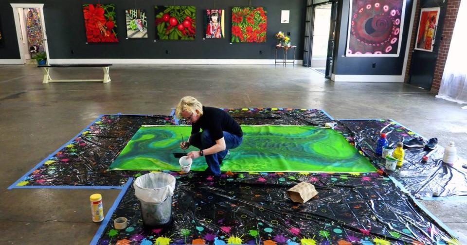 Dorota Quiroz works on an interactive painting at “Wanderlust & Art,” and exhibition in Columbus featuring nearly 300 of her works. the public is invited to help her paint it March 20 from 6 p.m. -8 p.m. and March 23 from Noon -2 p.m. 03/20/2024