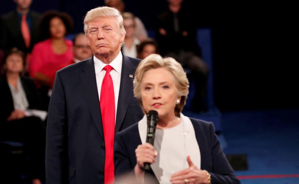 Republican presidential nominee Donald Trump listens as Democratic nominee Hillary Clinton answers a question from the audience during their presidential town hall debate at Washington University in St. Louis, Missouri, on Oct. 9, 2016.