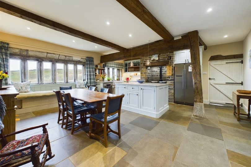 Stylish dining kitchen - the room boasts Indian-stone flagged flooring and exposed beams