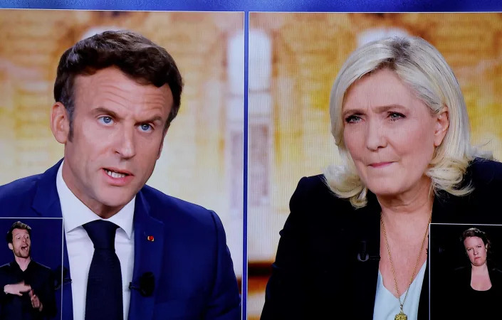 A picture shows screens displaying a live televised between French President Emmanuel Macron (left) and French far-right presidential candidate Marine Le Pen broadcasted on French TV channels TF1 and France 2, in a viewing room at the studios hosting the debate in Saint-Denis, France, ahead of the second round of France's presidential election.