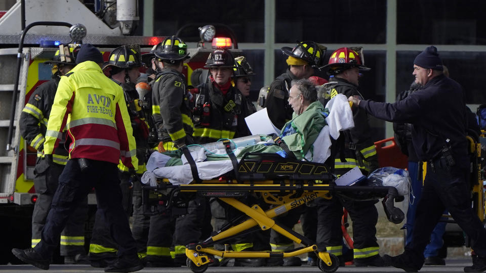 A patient, center, is transported on a gurney while being evacuated from Signature Healthcare Brockton Hospital, Tuesday, Feb. 7, 2023, in Brockton, Mass. A fire at the hospital's electrical transformer forced an undetermined number of evacuations Tuesday morning and power was shut off to the building for safety reasons, officials said. (AP Photo/Steven Senne)