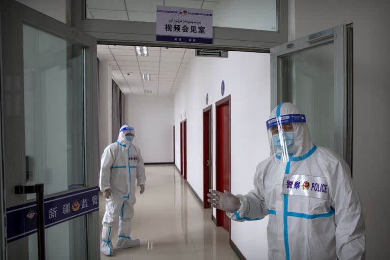 Agentes de seguridad con trajes protectores se encuentran en un pasillo con salas para videoconferencias con los reclusos en la sala de visitantes. (AP Photo/Mark Schiefelbein)