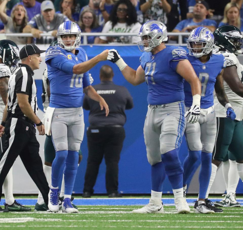 Detroit Lions quarterback Jared Goff (16) and guard Logan Stenberg (71) fist bump after a first down against the Philadelphia Eagles at Ford Field, Sept. 11, 2022.