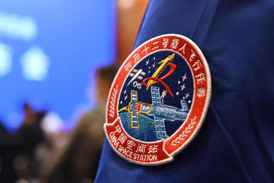 Image: A staff member of the Jiuquan Satellite Launch Centre wears the logo of China's new space station during a press conference about the first crewed mission to the station, China (Greg Baker / AFP - Getty Images)