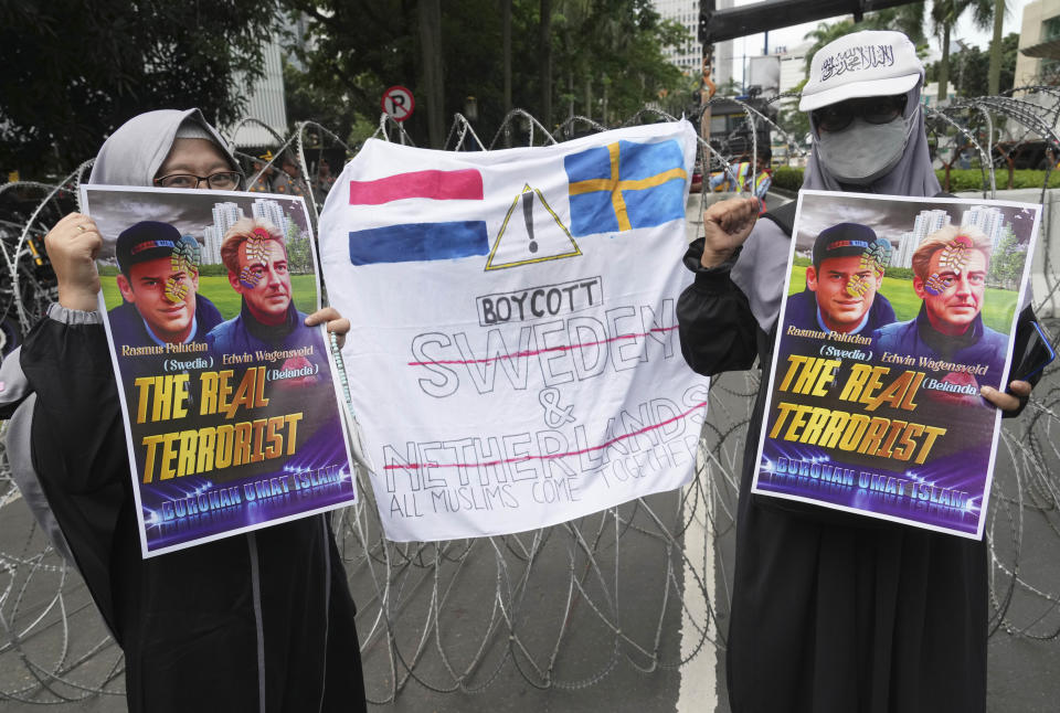 Muslim protesters hold posters during a rally outside the Swedish Embassy in Jakarta, Indonesia, Monday, Jan. 30, 2023. Hundreds of Indonesian Muslims marched to the heavily guarded Swedish Embassy in the country's capital on Monday to denounce the recent desecration of Islam's holy book by far-right activists in Sweden and the Netherlands. (AP Photo/Tatan Syuflana)