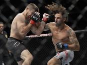Jim Miller, left, gets punched by Clay Guida, right, during the first round of a lightweight mixed martial arts bout at UFC Fight Night Saturday, Aug. 3, 2019, in Newark, N.J. Miller stopped Guida in the first round. (AP Photo/Frank Franklin II)