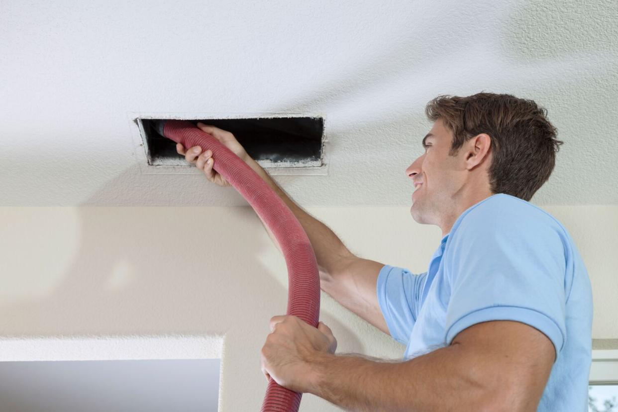 man cleaning duct and vent