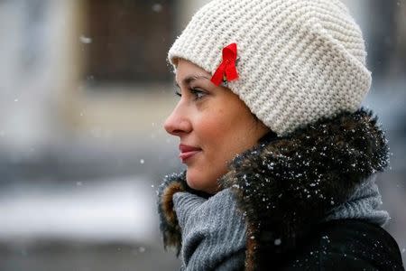 A woman with a red ribbon symbolising the fight against the HIV virus takes part in a ceremony to mark World AIDS Day near a monument in memory of AIDS victims in Kiev, Ukraine December 1, 2016. REUTERS/Gleb Garanich