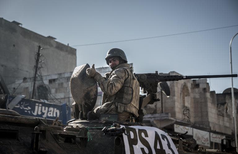 A Turkish soldier thumbs up on top of an army vehicle in a street of the Syrian town of Kobane, (aka Ain al-Arab) on February 22, 2015, during an operation to relieve the garrison guarding the Suleyman Shah mausoleum in northern Syria