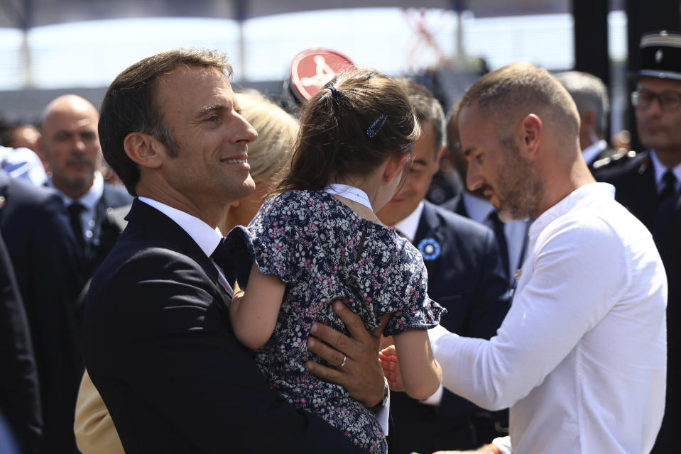 French President Emmanuel Macron carries a girl after the Bastille Day military parade Friday, July 14, 2023 in Paris. India is the guest of honor at this year's Bastille Day parade, with Prime Minister Narendra Modi in the presidential tribune alongside French President Emmanuel Macron. (AP Photo/Aurelien Morissard, Pool)