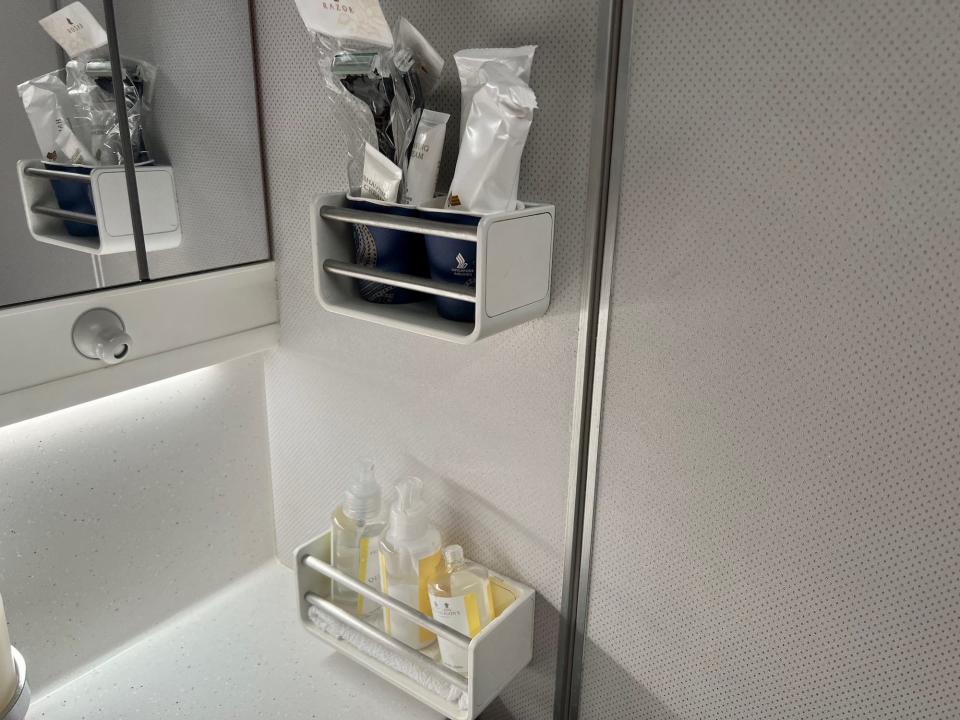 The small shelves with toiletries in the lavatory.