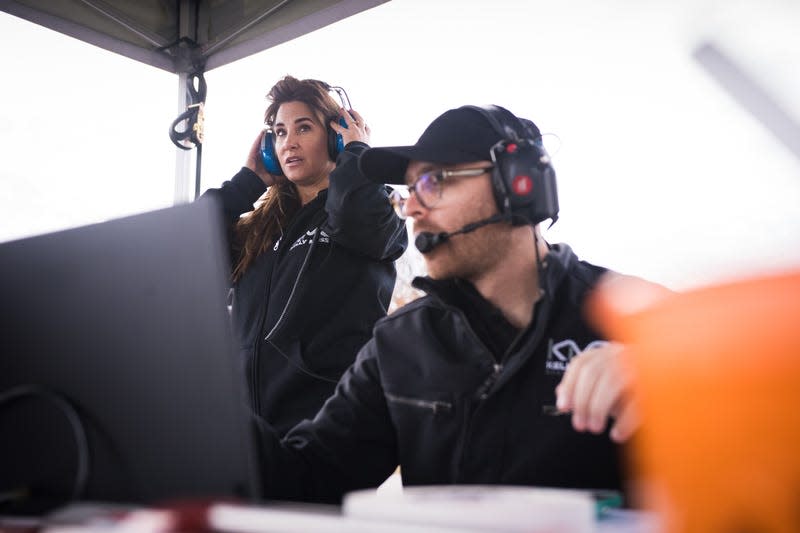 KellyMoss Co-Owner Victoria Thomas, left, watching the three women driver finalists on track.