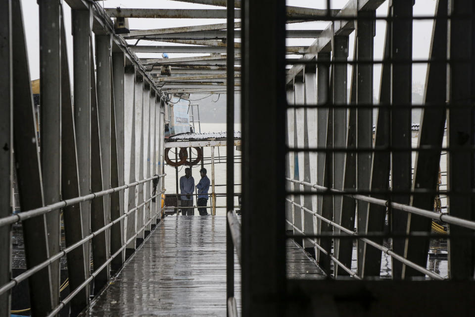 Security officers stand on an empty jetty leading to a ferry service, suspended due to cyclonic storm, on the Hooghly River in Kolkata, India, Saturday, Nov. 9, 2019. Authorities in nearby Bangladesh put more than 50,000 volunteers on standby and readied about 5000 shelters as a strong cyclone in the Bay of Bengal is expected to hit the low-lying nation's vast southwestern and southern coast on Saturday evening. (AP Photo/Bikas Das)