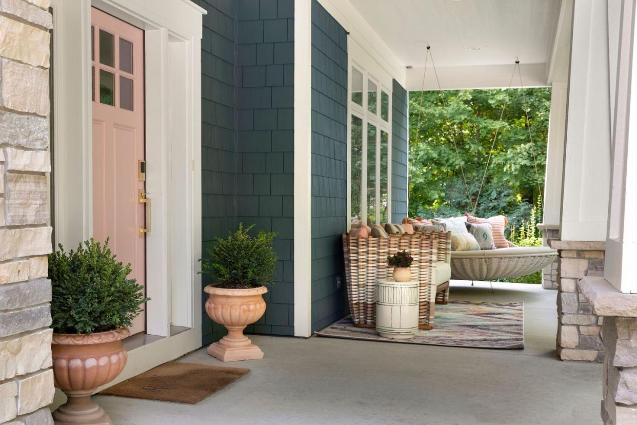 a house with a patio and a patio with a bench and plants