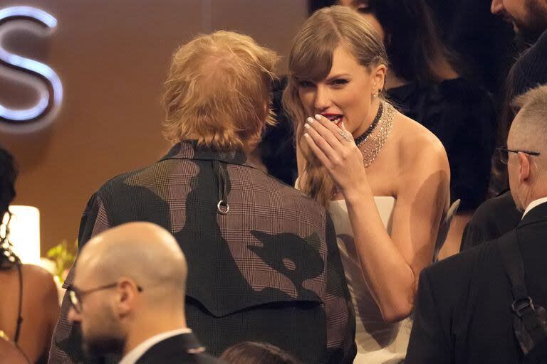 Swift chusmea con el músico Ed Sheeran durante la ceremonia; el cantante inglés ha contado anteriormente que ambos son muy amigos y han tenido 