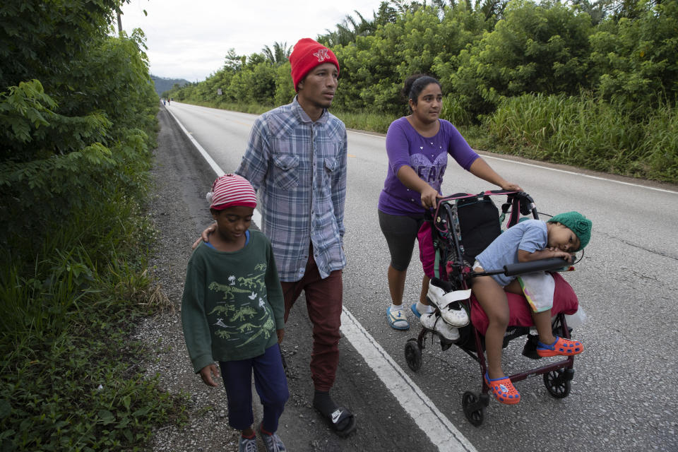 Honduras migrant Marcos Pineda, his wife Keysi Giron and their children Genesis and Ezequiel walk through San Luis Peten, Guatemala, Saturday, Oct. 3, 2020. Early Saturday, hundreds of migrants who had entered Guatemala this week without registering were being bused back to their country's border by authorities after running into a large roadblock. (AP Photo/Moises Castillo)