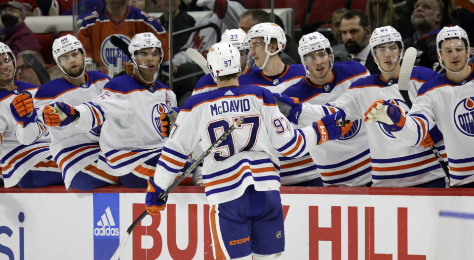 Edmonton Oilers center Connor McDavid (97) is congratulated for his goal during the third period of the team's NHL hockey game against the Carolina Hurricanes on Thursday, Nov. 10, 2022, in Raleigh, N.C. (AP Photo/Chris Seward)