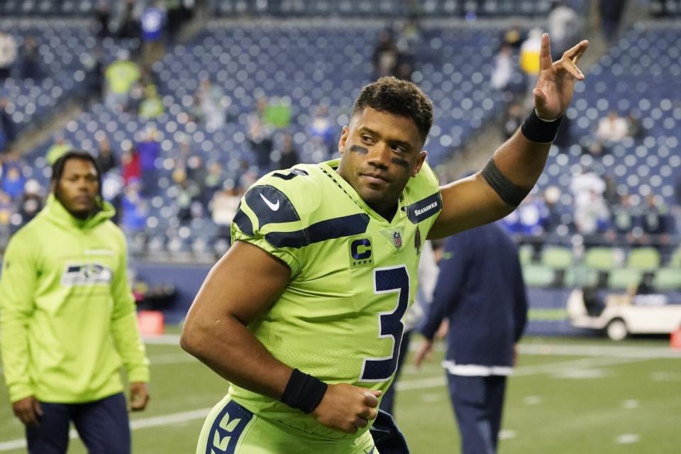 Seattle Seahawks quarterback Russell Wilson waves to fans as he leaves the field.