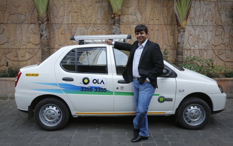 Bhavish Aggarwal, CEO and co-founder of Ola, an app-based cab service provider, poses in front of an Ola cab in Mumbai