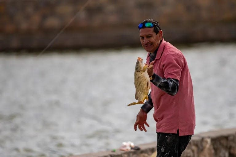 A fisherman prepares to release his catch into the lake at Ascarate Park on Nov. 13.