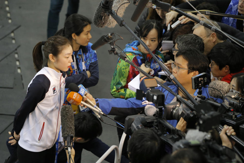 Yuna Kim of South Korea, left, speaks with the media after a training session at the figure skating practice rink at the 2014 Winter Olympics, Thursday, Feb. 13, 2014, in Sochi, Russia. (AP Photo/Vadim Ghirda)