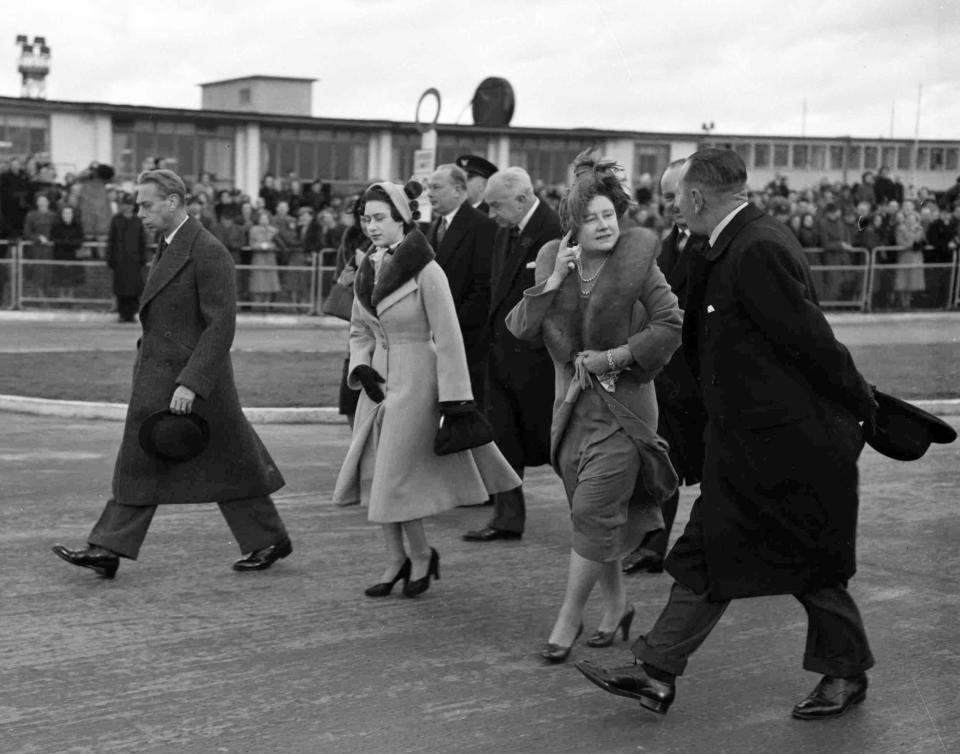 Britain's King George VI, left, with his wife Queen Elizabeth, second right, and their younger daughter Princess Margaret cross the tarmac at London Airport, on Jan. 31, 1952, to say farewell to Princess Elizabeth and her husband Prince Philip, the Duke of Edinburgh at the start of their 30,000 mile tour of Kenya, Ceylon, Australia and New Zealand.  (AP Photo)