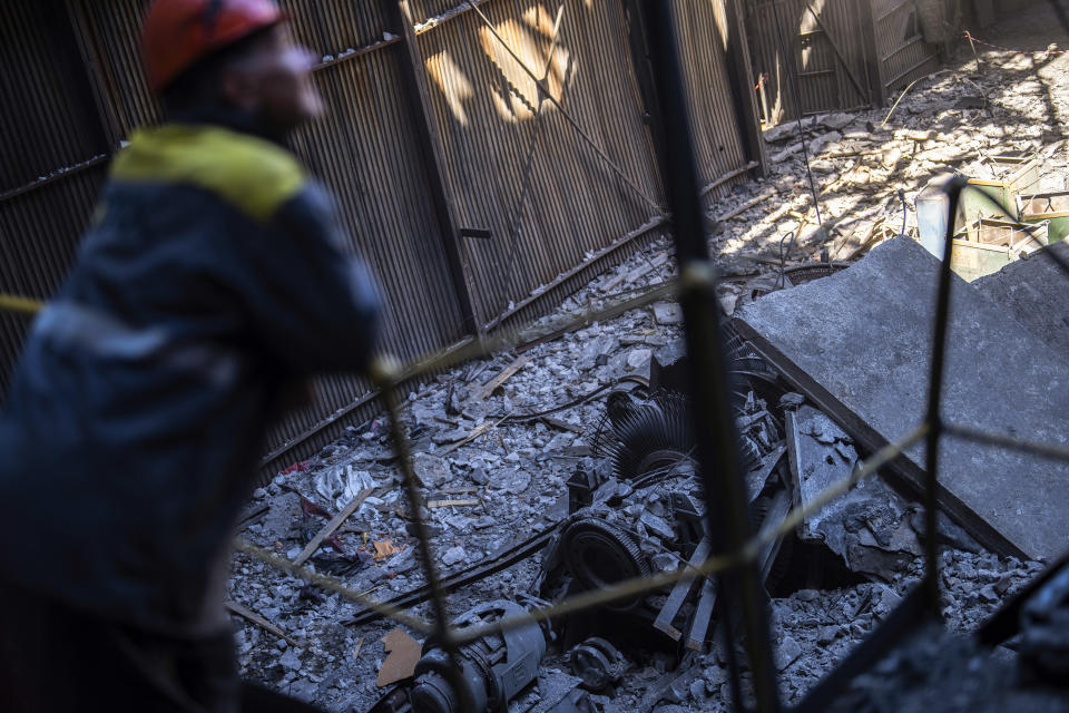 A worker stands next to debris in a damaged DTEK thermal power plant after a Russian attack in Ukraine, Thursday, May 2, 2024. Ukrainian energy workers are struggling to repair the damage from intensifying airstrikes aimed at pulverizing Ukraine's energy grid, hobbling the economy and sapping the public's morale. (AP Photo/Francisco Seco)