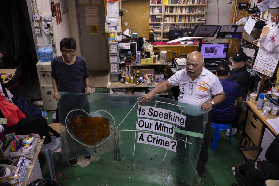 The Bull" Tsang Kin-shing, right, founder of Hong Kong's pro-democracy Citizens' Radio station, holds a banner prior to the radio's last broadcast in Hong Kong, Friday, June 30, 2023. (AP Photo/Louise Delmotte)