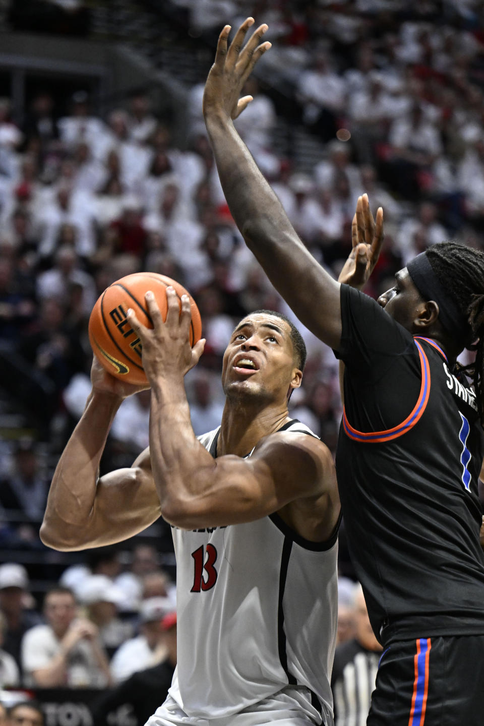 San Diego State forward Jaedon LeDee (13) looks for a shot against Boise State forward O'Mar Stanley (1) during the second half of an NCAA college basketball game Friday, March 8, 2024, in San Diego. (AP Photo/Denis Poroy)