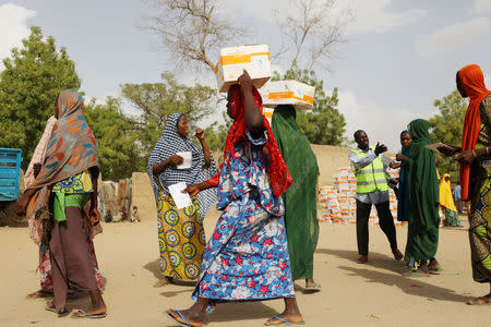 Women carry food supplement received from World Food Programme (WFP) at the Banki IDP camp, in Borno, Nigeria April 26, 2017. REUTERS/Afolabi Sotunde