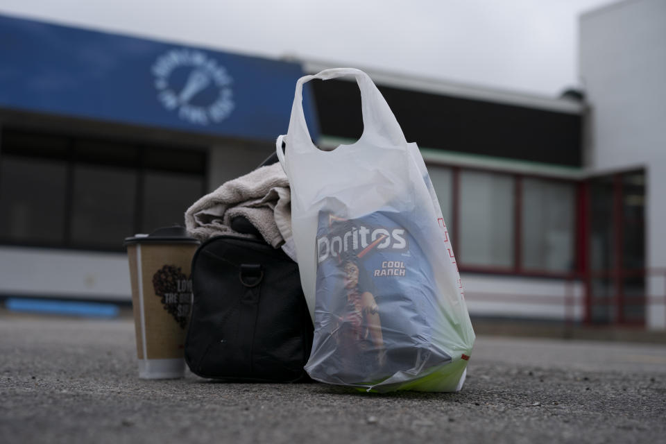 In this April 5, 2020, photo truck driver's Sammy Lloyd's shower kit, coffee and Doritos sit on the pavement at the TA Travel Center truck stop in Foristell, Mo., before Lloyd heads out to continue driving a COVID-19 emergency relief load he picked up in California to Virginia. (AP Photo/Carolyn Kaster)