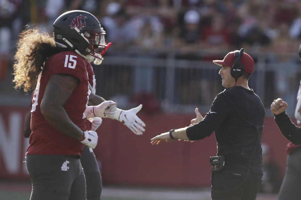 Washington State head coach Jake Dickert, right, greets his players during a break in play in the first half of an NCAA college football game against Wisconsin, Saturday, Sept. 9, 2023, in Pullman, Wash. (AP Photo/Young Kwak)