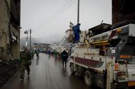 Japanese workers repair electricity cables among destroyed houses and debris in the tsunami-damaged town of Otsuchi, in Iwate prefecture. Radiation levels have surged in seawater near a tsunami-stricken nuclear power station in Japan, officials said Saturday, as engineers battled to stabilise the plant in hazardous conditions