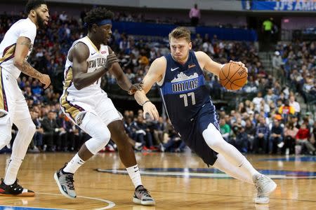 Dec 26, 2018; Dallas, TX, USA; Dallas Mavericks forward Luka Doncic (77) drives around New Orleans Pelicans guard Jrue Holiday (11) during the first half at American Airlines Center. Mandatory Credit: Andrew Dieb-USA TODAY Sports